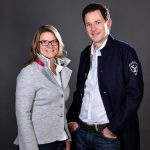 Professionelles Portrait eines Paares im eleganten Look für die Unternehmenspräsentation Portrait eines Paares in stilvoller Kleidung, lächelnd vor einem neutralen Hintergrund, ideal für Unternehmenskommunikation.