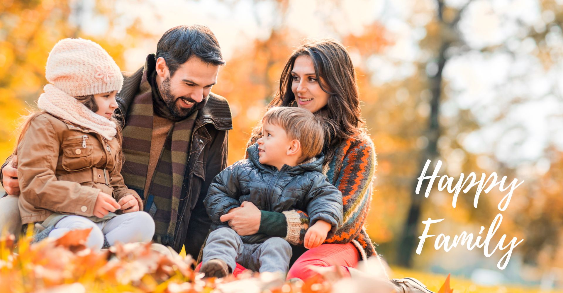 Eine fröhliche Familie sitzt im herbstlichen Park, umgeben von bunten Blättern, und verbringt wertvolle Zeit miteinander.