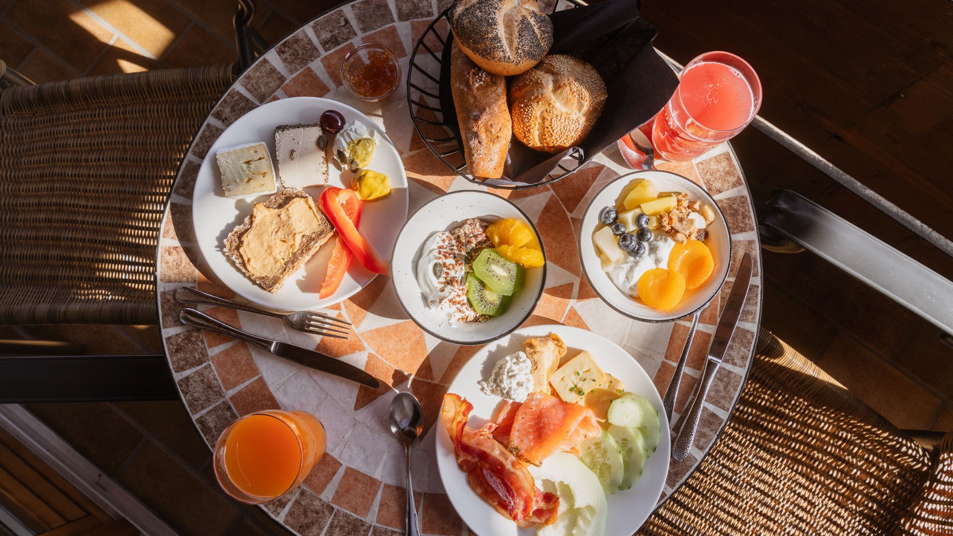 Ein reichhaltiges Frühstück im Familienhotel, bestehend aus frischen Brötchen, Obstsalat und Joghurt, perfekt für den Urlaub.