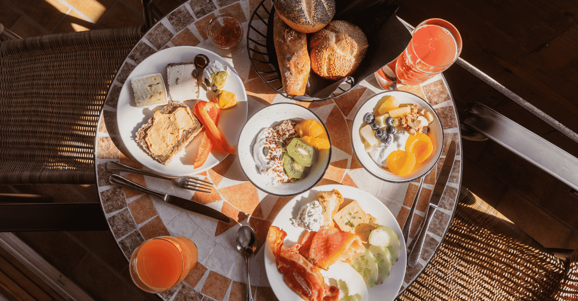Leckeres Frühstück im Hotel Alpenglück mit frischen Brötchen, Obst und Müsli auf der Terrasse Frühstück im Hotel Alpenglück mit einer Auswahl an frischen Brötchen, Obst und Müsli, ideal für den Familienurlaub.