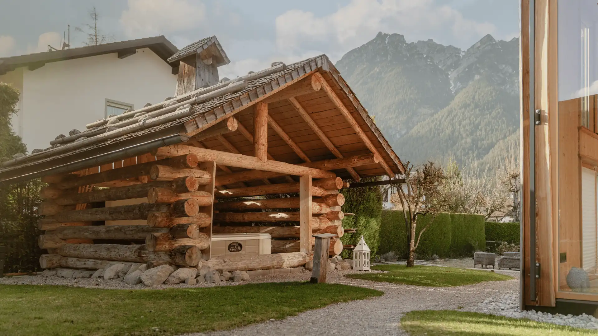 Holzscheune im Garten mit Blick auf die Berge, ideal für Familienurlaub in der Natur, umgeben von Grünflächen.