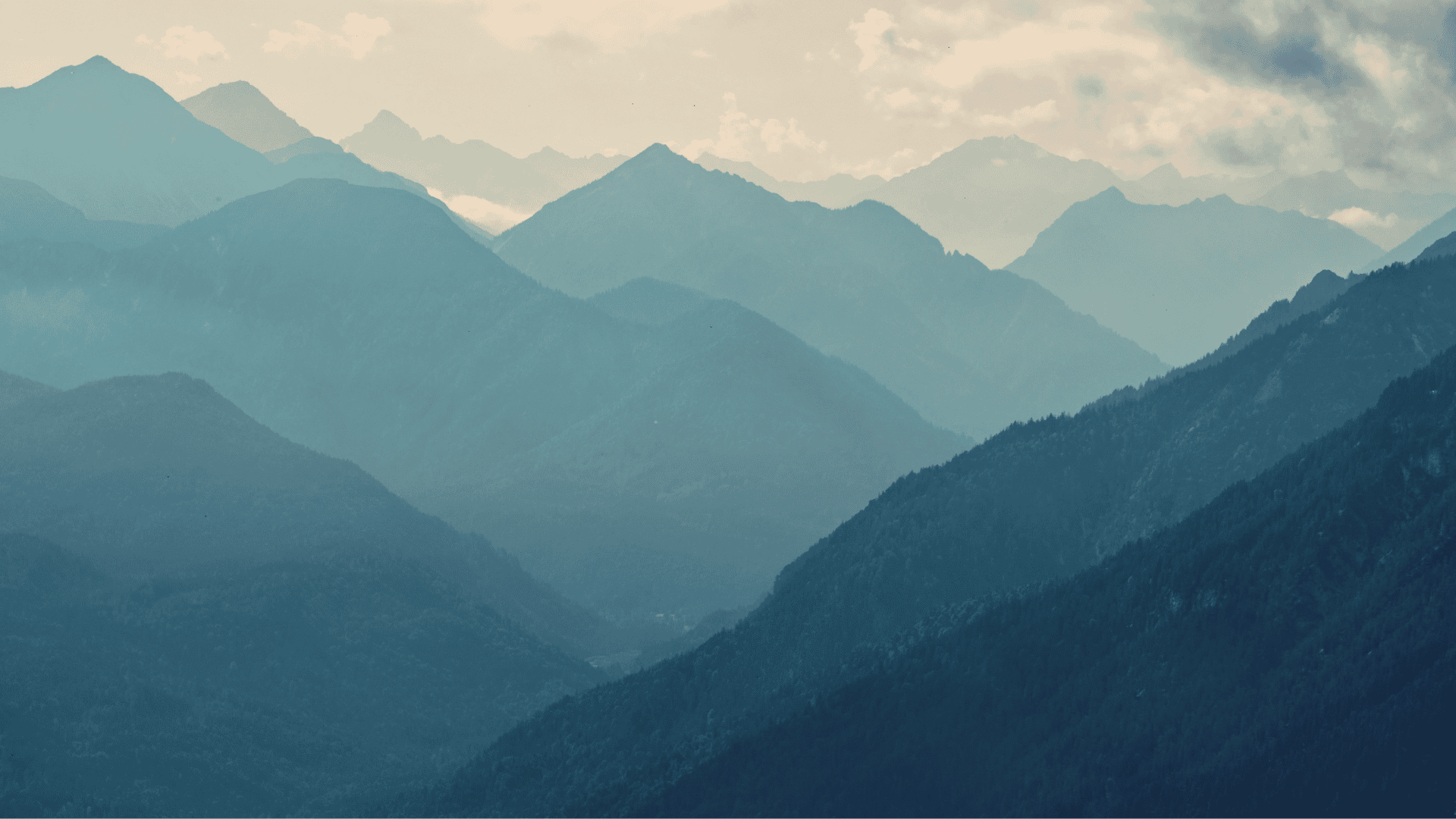 Die beeindruckende Berglandschaft der Alpen mit sanften Hügeln und Nebel, ideal für Wanderungen und Naturerlebnisse im Familienurlaub.