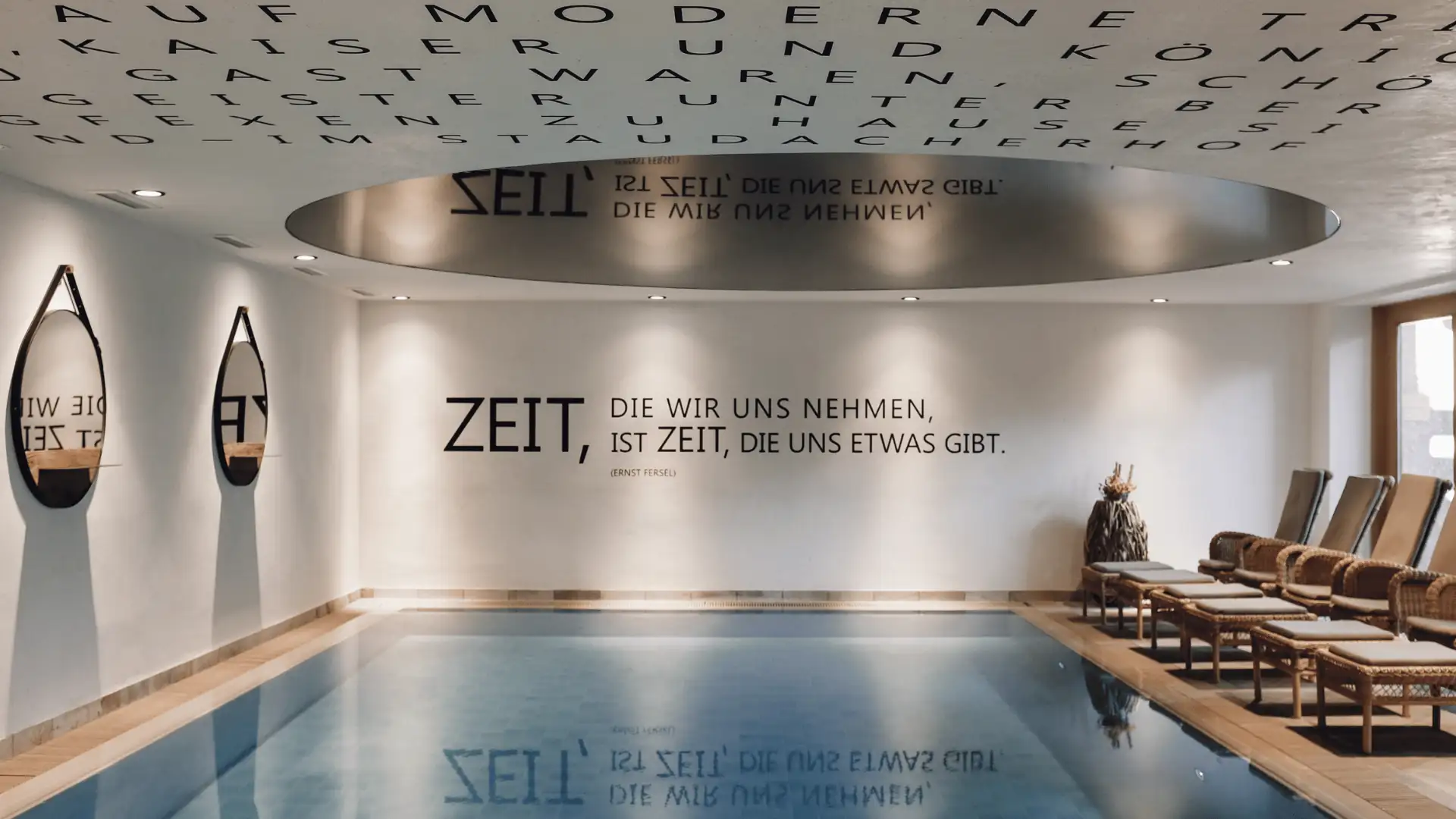Modernes Hotel mit Poolbereich, an der Wand stehen inspirierende Zitate, die für Entspannung und Zeit für sich selbst werben.